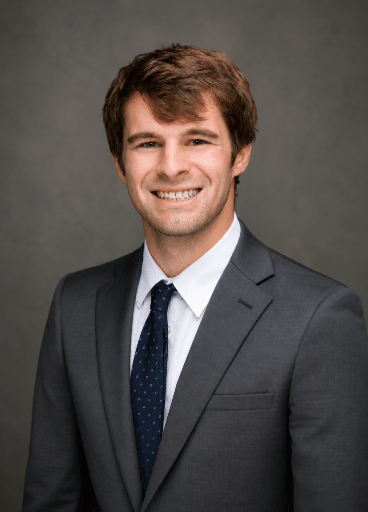 Professional headshot of a smiling man in a gray suit and navy tie against a neutral backdrop, studio lighting.] ,? image0 - Oliver Law Office image0 - Oliver Law Office